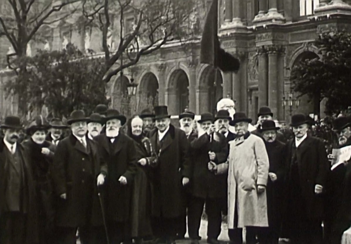 Tiré du film d’Armand Guerra, La Commune (1914) - Un groupe de l'Asso­ciation fraternelle des anciens combat­tants de la Commune sont réunis devant le Louvre, sont reconnaissables Zéphirin Camélinat, Jean Allemane, Nathalie Lemel