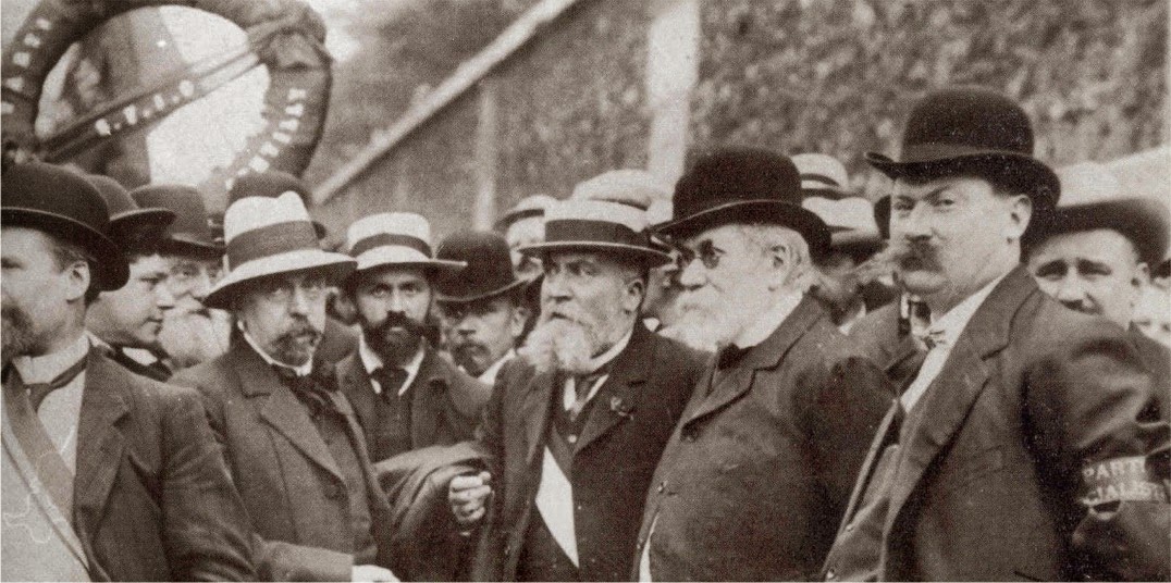 Délégation de la SFIO (Section Française de l’Internationale Ouvrière) au mur des Fédérés, Cimetière du Père Lachaise, mai 1913. Édouard Vaillant en face, portant un canotier et à sa droite Jean Jaures portant un chapeau melon. )