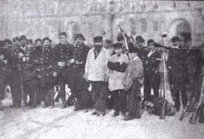 Apprentis au milieu de fédérés posant devant la Colonne Vendôme démolie.