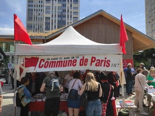 Stand des Amies et Amis de la Commune, place des Fêtes avant la montée au Mur en mai 2023